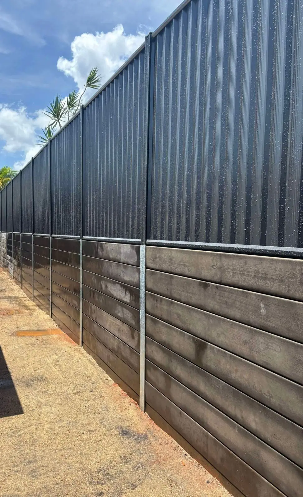 Black Colorbond fence on charcoal sleepers