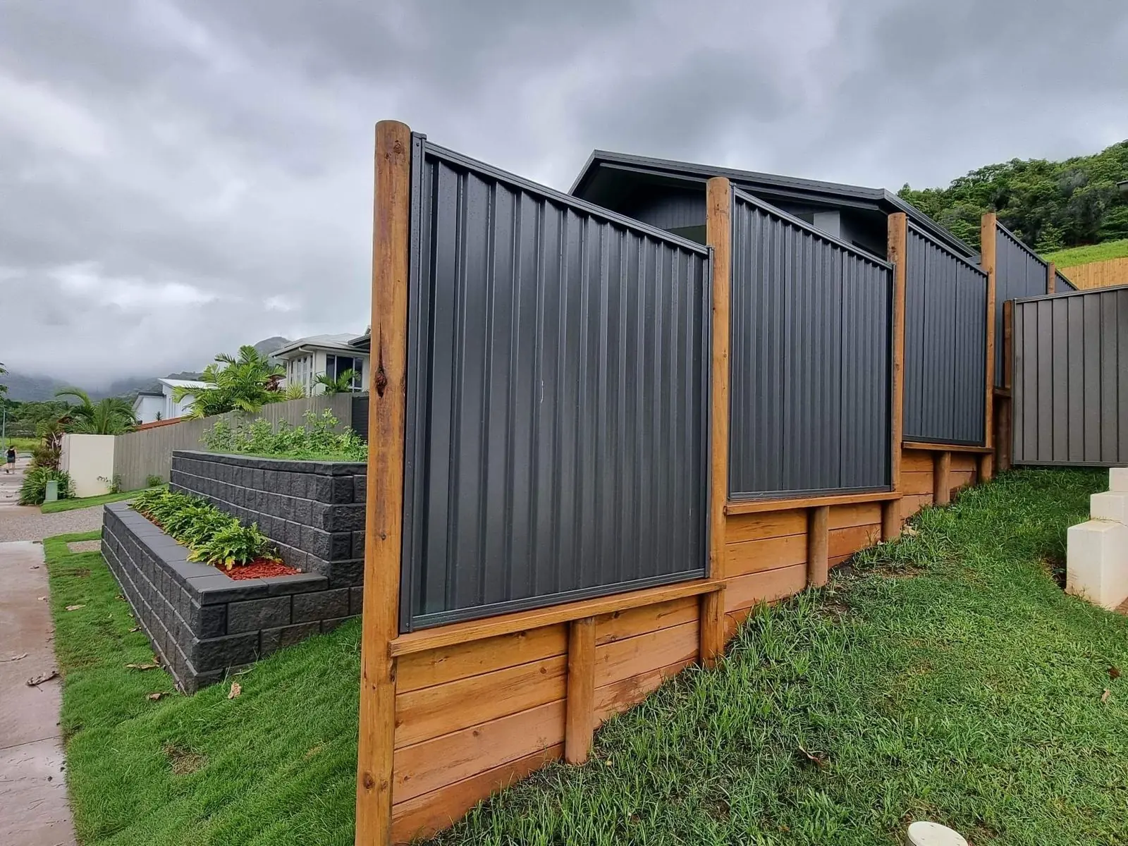 Stepped Colorbond panels on a timber sleeper wall