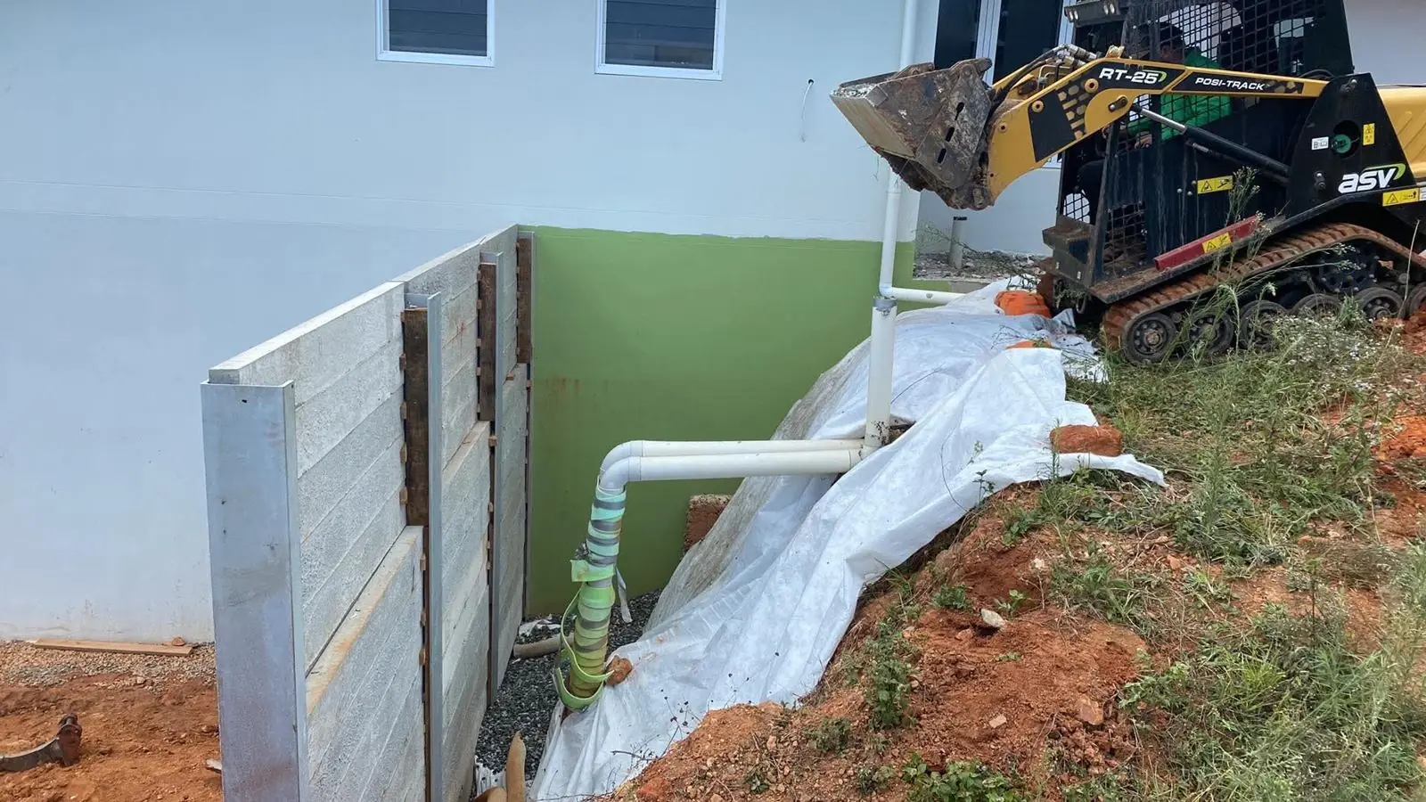 Downpipe connected into wall drainage behind a new concrete sleeper retaining wall