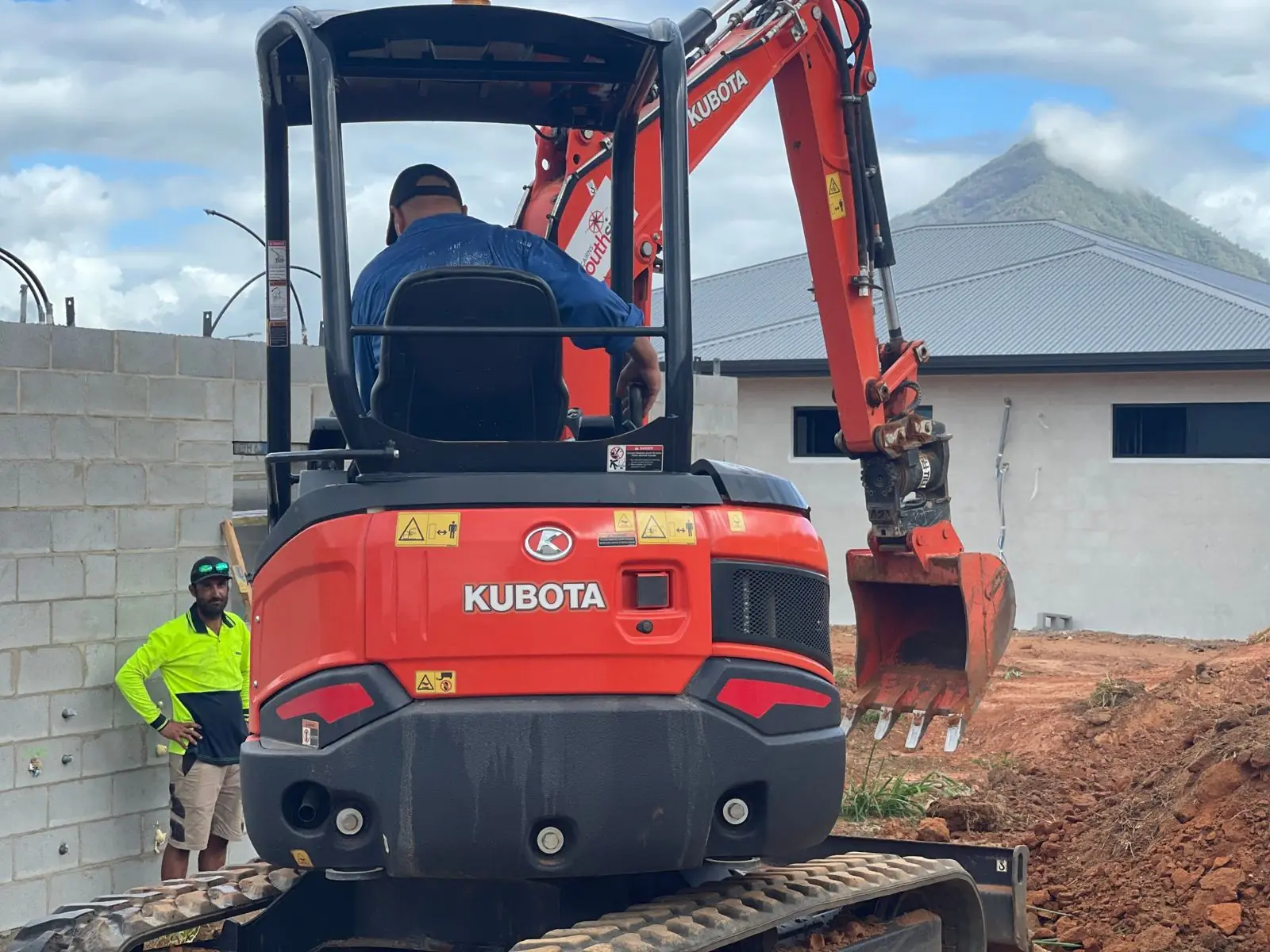 Crew with a Kubota excavator on a Cairns build site