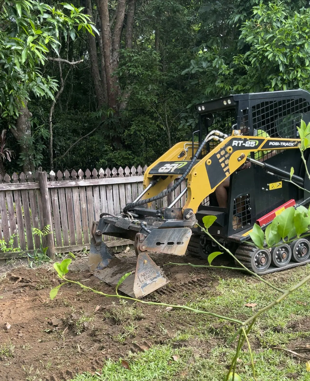 Track loader levelling a backyard
