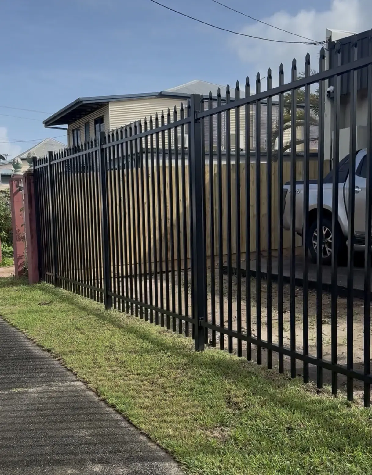 Black press-top aluminium fence along a street boundary