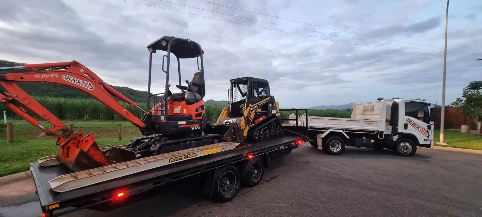 QuickDig Kubota excavator and ASV track loader on a trailer with the QuickDig tipper