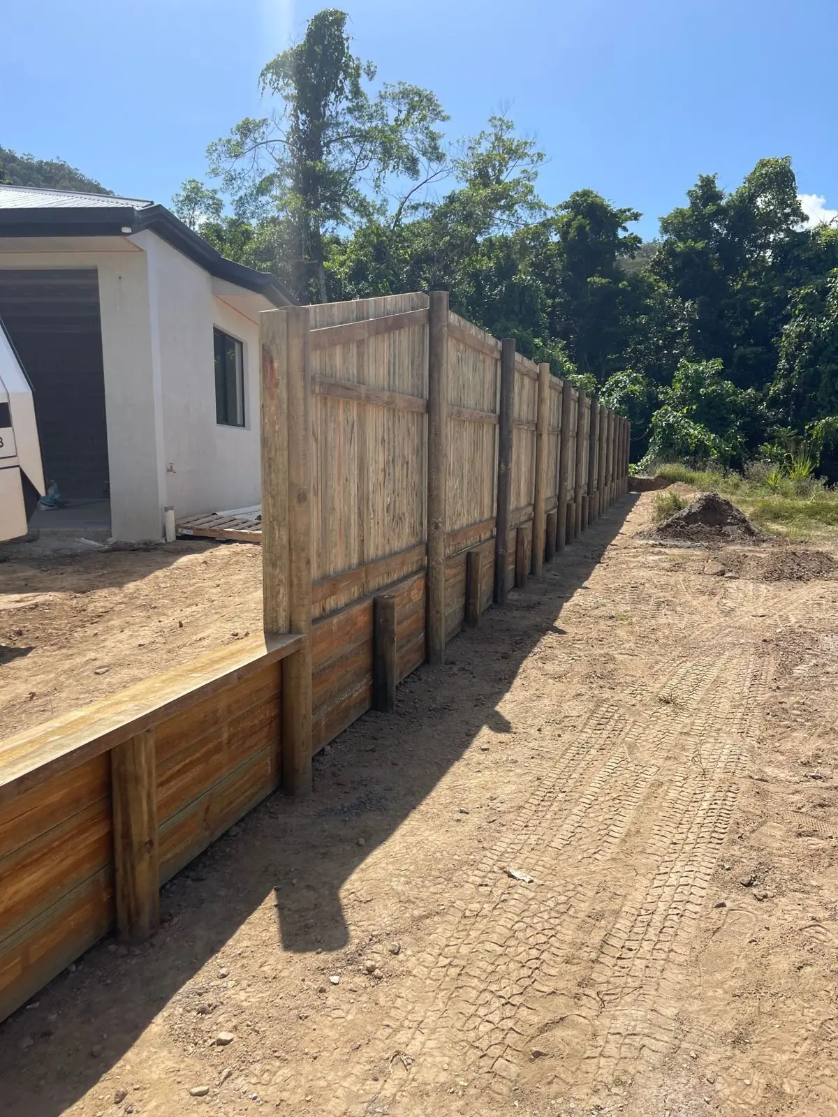 Timber retaining wall with timber fence above