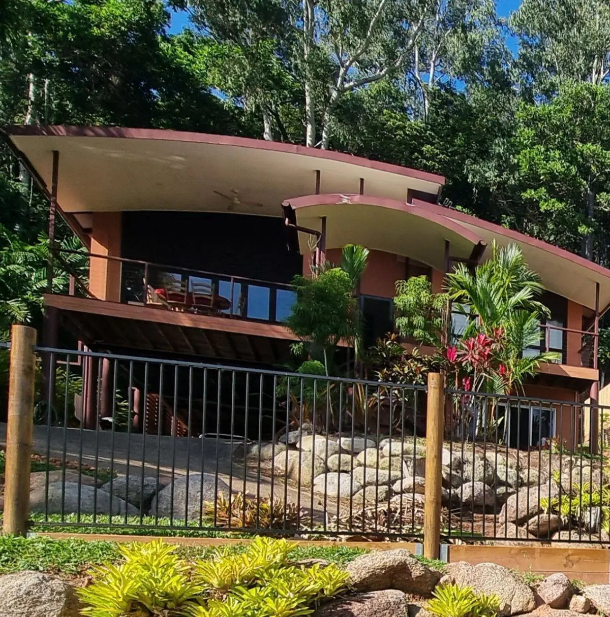 Tropical garden with boulders and pool fence